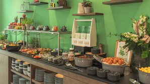 A buffet setup with various food items and containers, shelves with baskets and jars, and a glass display case. - Holiday Inn - the niu, Hop Forchheim by IHG (Forchheim)