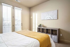 Ein Schlafzimmer mit einem Bett, einem Konsolentisch und einem Wandbild.