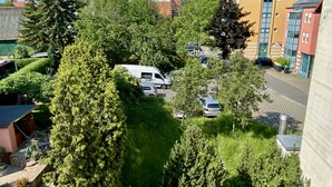 A residential area with a white van parked in a driveway, surrounded by lush greenery and trees. - Ferienwohnung am Jacobsweg (Wurzen)