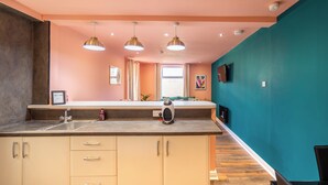 Een moderne keuken met een centraal eiland, hanglampen en uitzicht op een eetgedeelte.