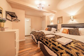 Une chambre d’hôtel avec deux lits, un bureau et un miroir.