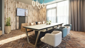 A modern conference room with a wooden wall, a large table, and several chairs. - Holiday Inn - the niu, Brass Munich Olympiapark by IHG (Munich)