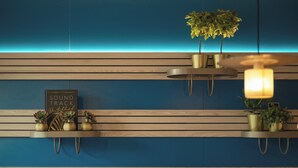 A wall with horizontal wooden slats and two shelves with plants and a sign. - Holiday Inn - the niu, Brass Munich Olympiapark by IHG (Munich)