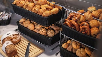 A display of various baked goods including bread, croissants, and pastries.