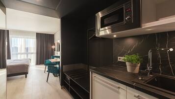 A modern kitchen with a built-in microwave, a sink, and a potted plant.