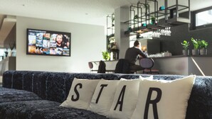 Un área de estar moderna con un sofá azul oscuro y una almohada con la palabra 'STAR'.