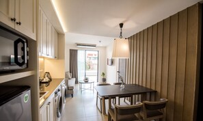 A modern kitchen with a dining area, built-in appliances, and a view to the outside. - Marina House MUAYTHAI Ta-iad Phuket (Chalong)