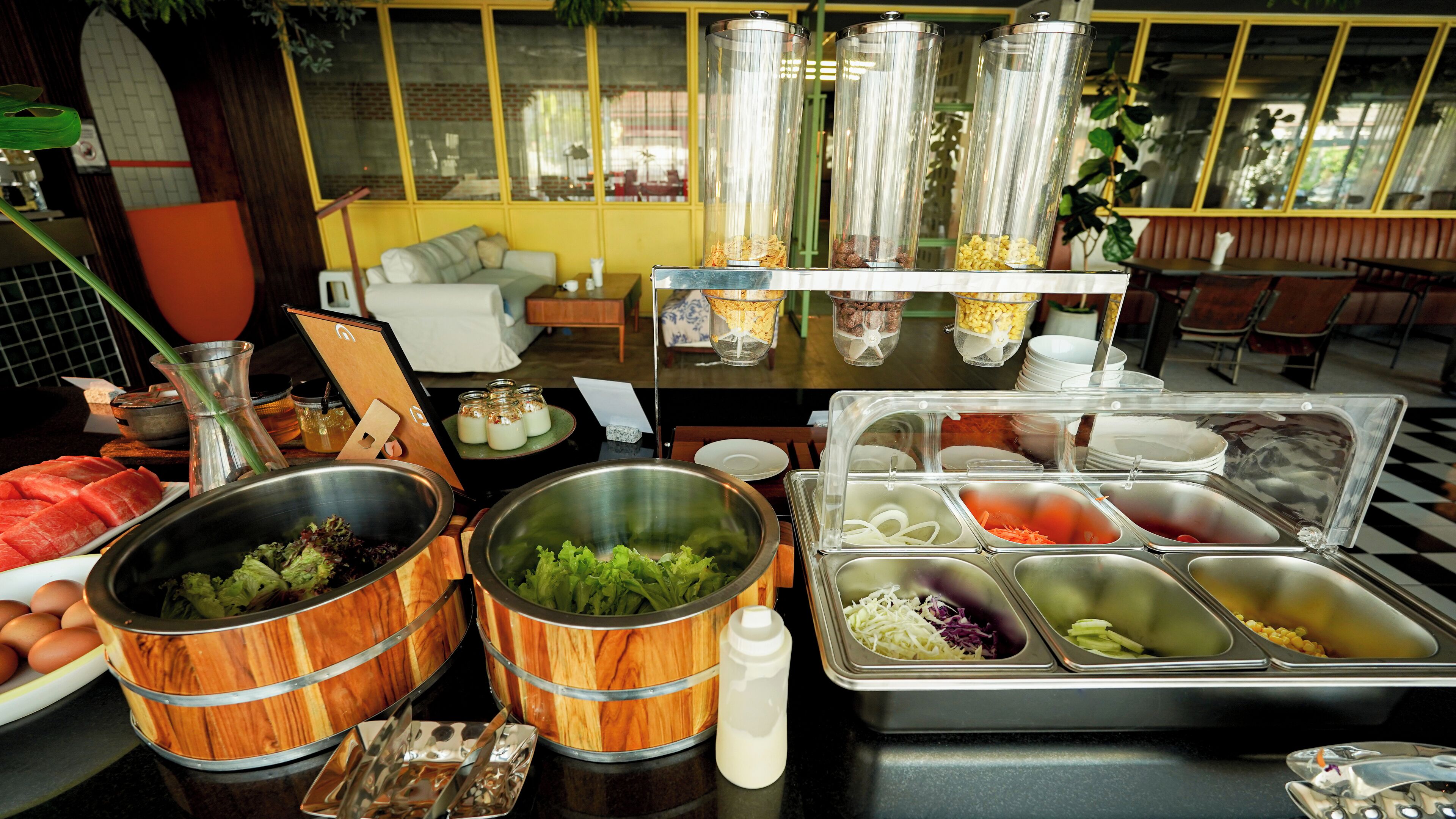 A buffet setup with various food items and utensils.