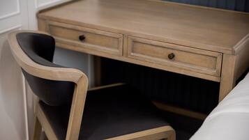 Un escritorio de madera con dos cajones y una silla negra de estructura de madera.