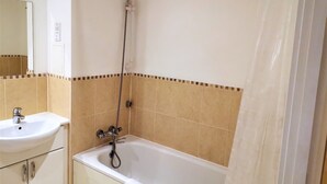 Une salle de bain avec une baignoire, un lavabo et une douche.