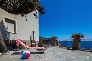 A stone patio with a beach ball, a hammock, and outdoor furniture.