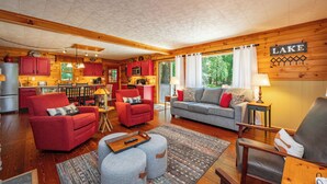 Ein gemütliches Blockhaushaus-Interieur mit Wohnzimmer, Küche und Essbereich.