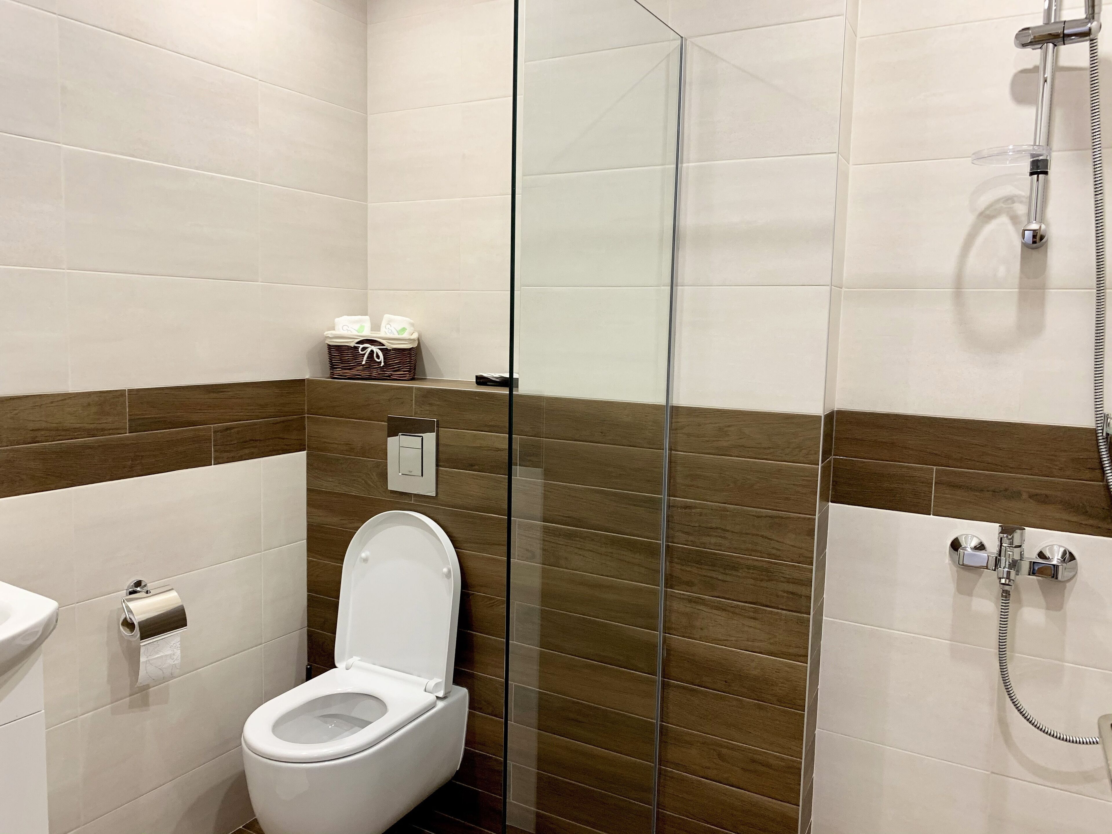Un baño moderno con cabina de ducha de vidrio, inodoro y lavamanos.
