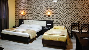 A hotel room with two beds, a desk, and two chairs. - Hotel Number One (Gjirokaster)