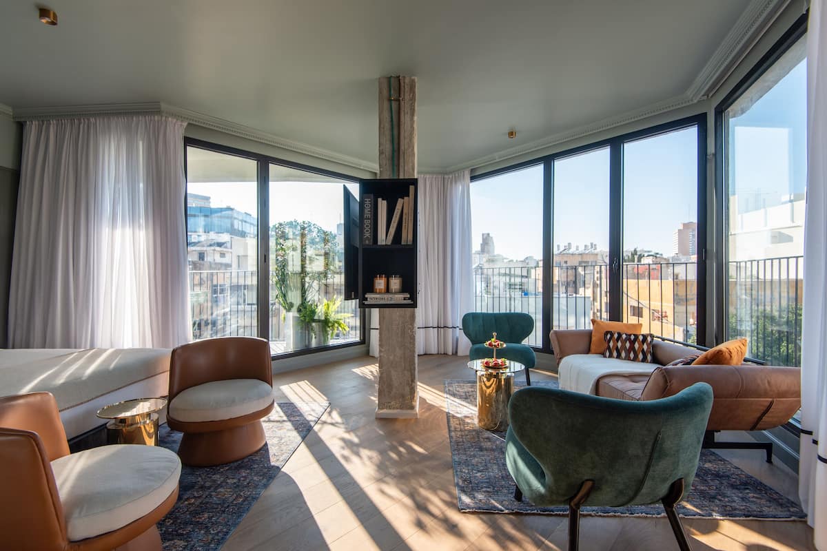 Un salón amplio con un gran ventanal, una estantería y muebles modernos.