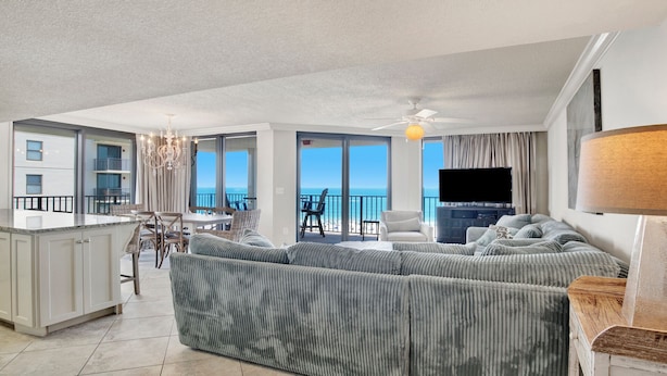 A spacious living area with a large sofa, a dining table, and a kitchen area.