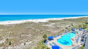 A resort with a large pool area, beach access, and a view of the ocean.