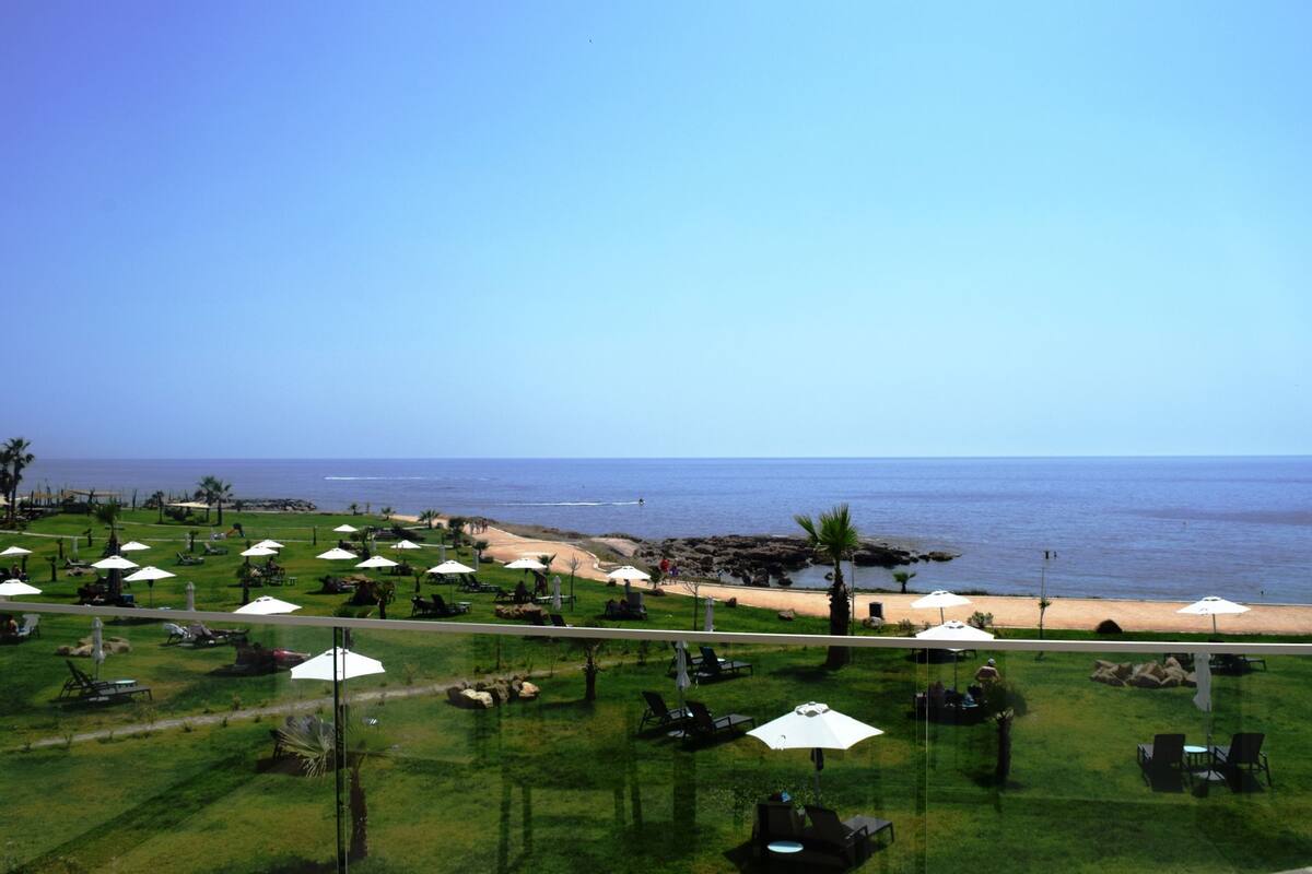Een resort met buitenzitgedeeltes, een strand en uitzicht op de oceaan.