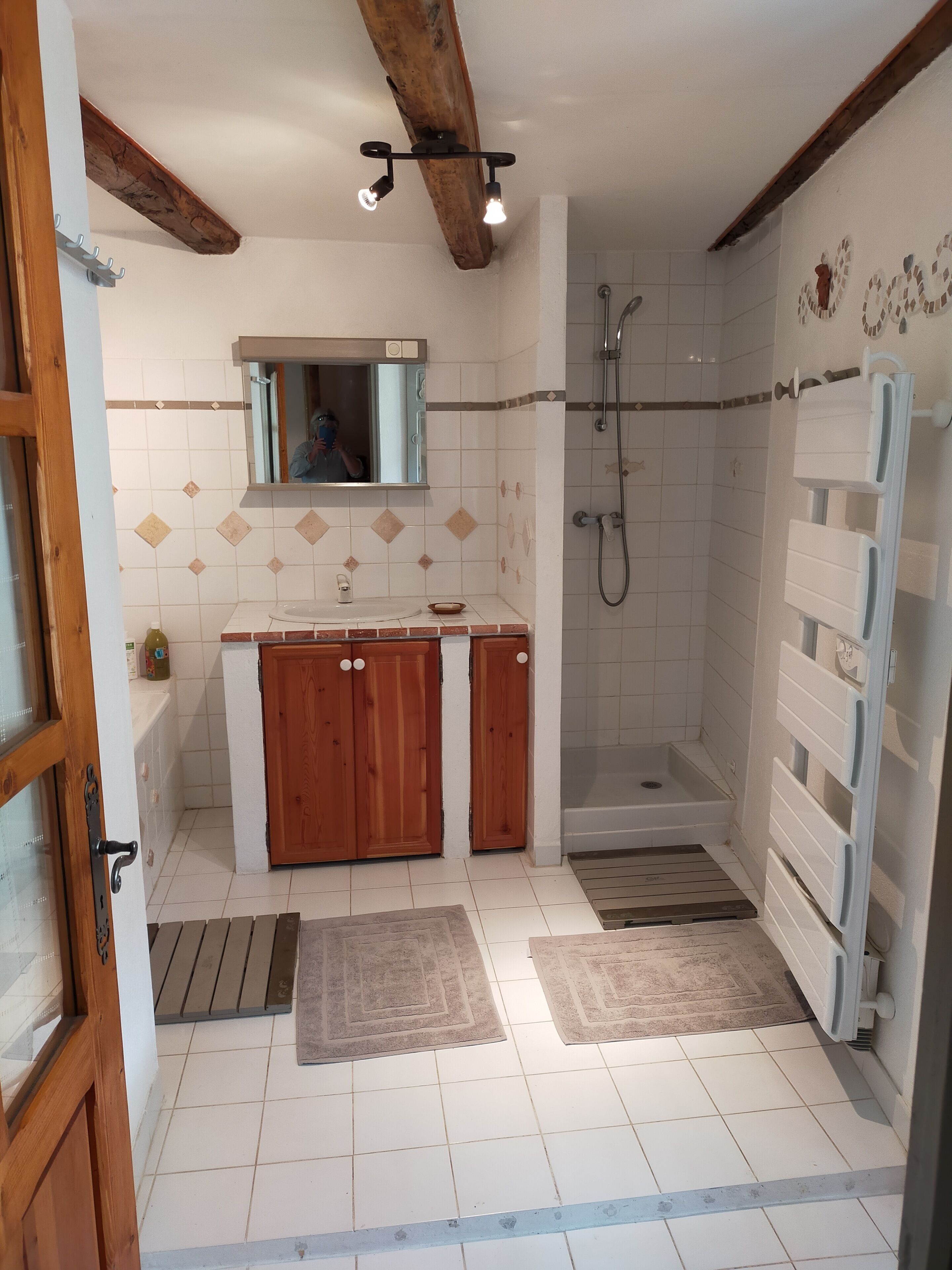 Een bad/douchecombinatie, een haardroger, handdoeken, toiletpapier