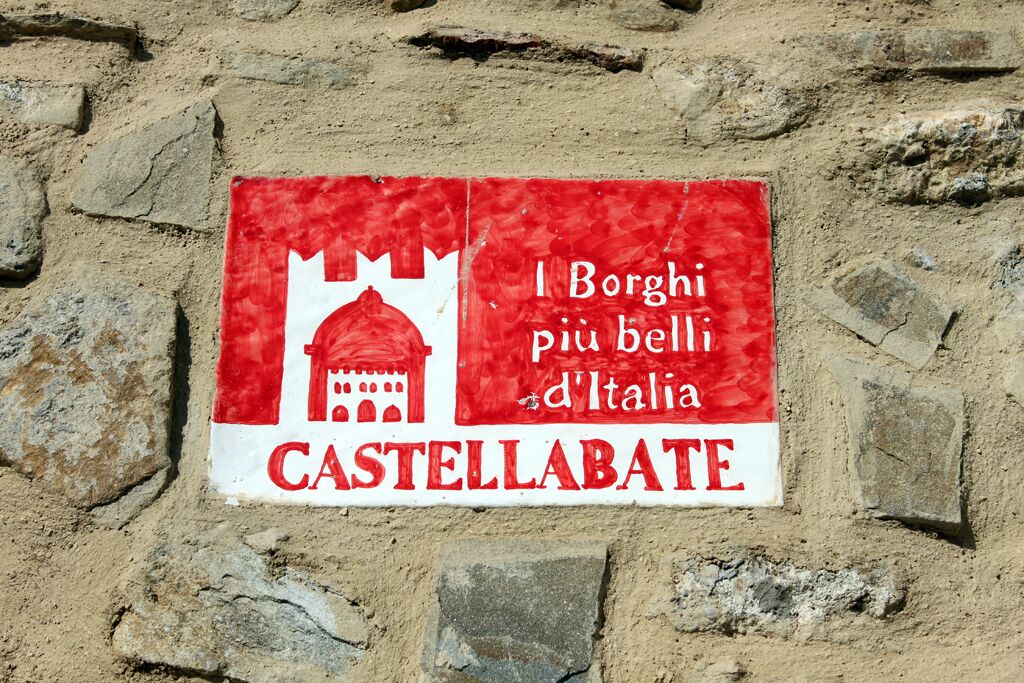 A sign with the text "I Borghi più belli d'Italia" and "CASTELLABATE" on a stone wall.