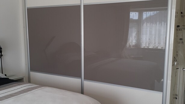 Ein Schlafzimmer mit Bett, Kleiderschrank und Fenster.