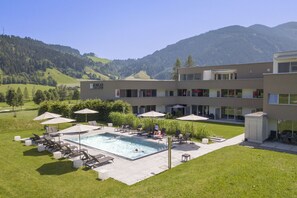 Hotel com piscina, área de estar ao ar livre e vista para as montanhas.