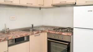 Une cuisine équipée d’une cuisinière à gaz, d’un four et d’un lave-vaisselle encastré.