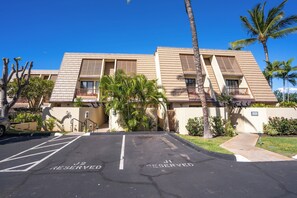 A hotel with a parking lot marked with "J2 RESERVED" and "J1 RESERVED" signs, indicating reserved parking spaces.