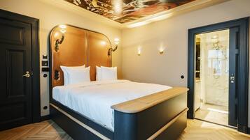 Un dormitorio moderno con una cama grande, cabecera de madera y un mural en el techo.