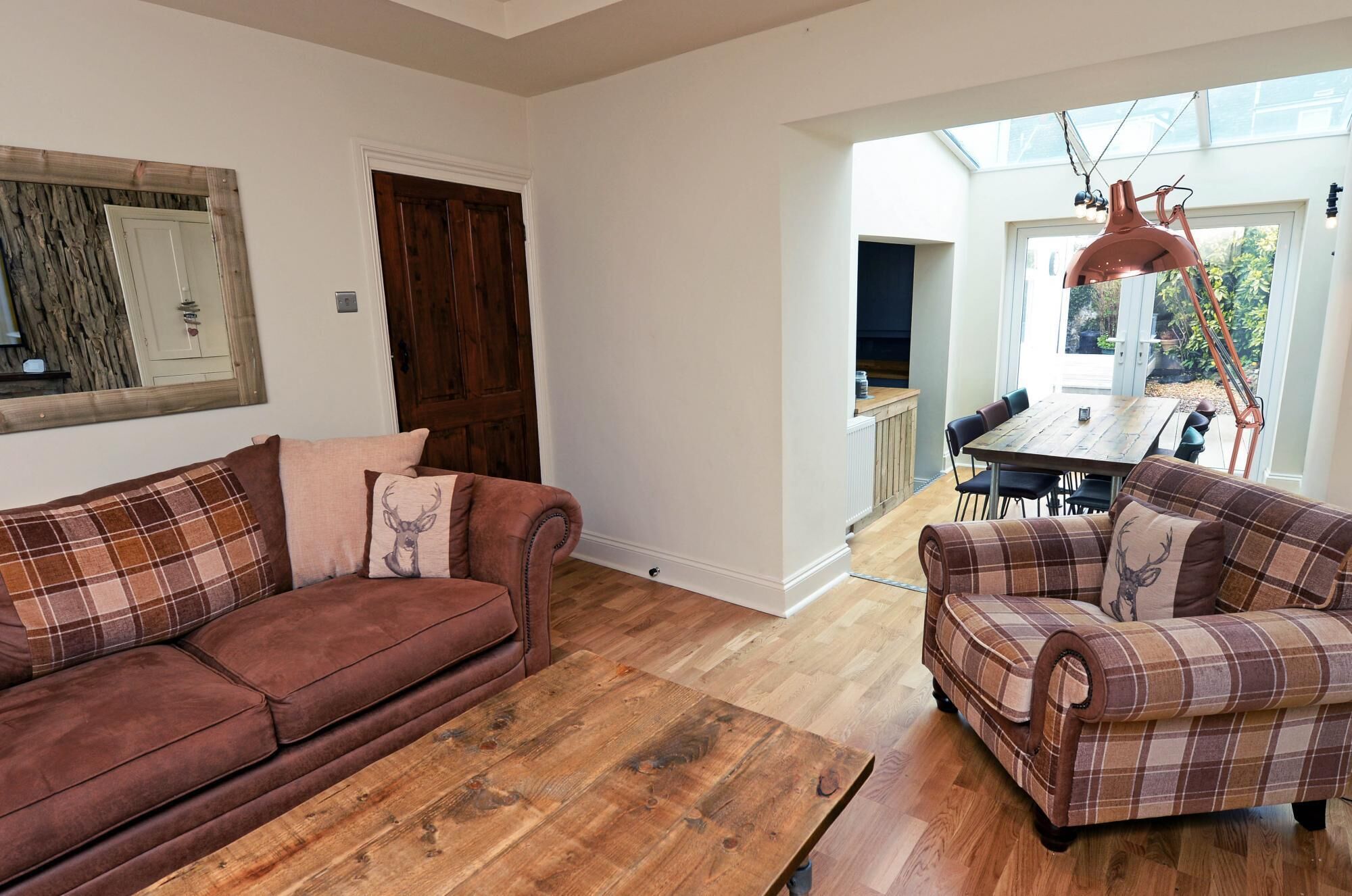 A living room with two sofas, a wooden coffee table, and a dining area with a table and chairs.