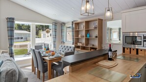Une cuisine moderne dotée d’un îlot central, de meubles en bois et d’un four encastré.