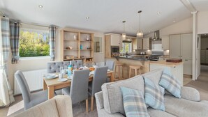 Une cuisine moderne dotée d’un îlot central, de meubles en bois et d’un four encastré.