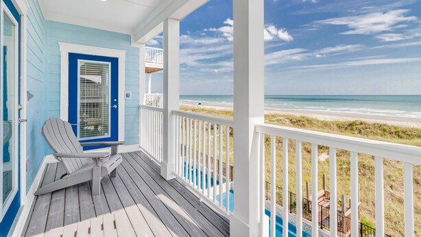 A covered porch with a view of the beach, a door with a window, and a chair. - THE OCEANFRONT GRAND RESORT: 17 BR Luxury with Unmatched Views+ALL THE AMENITIES (North Myrtle Beach)