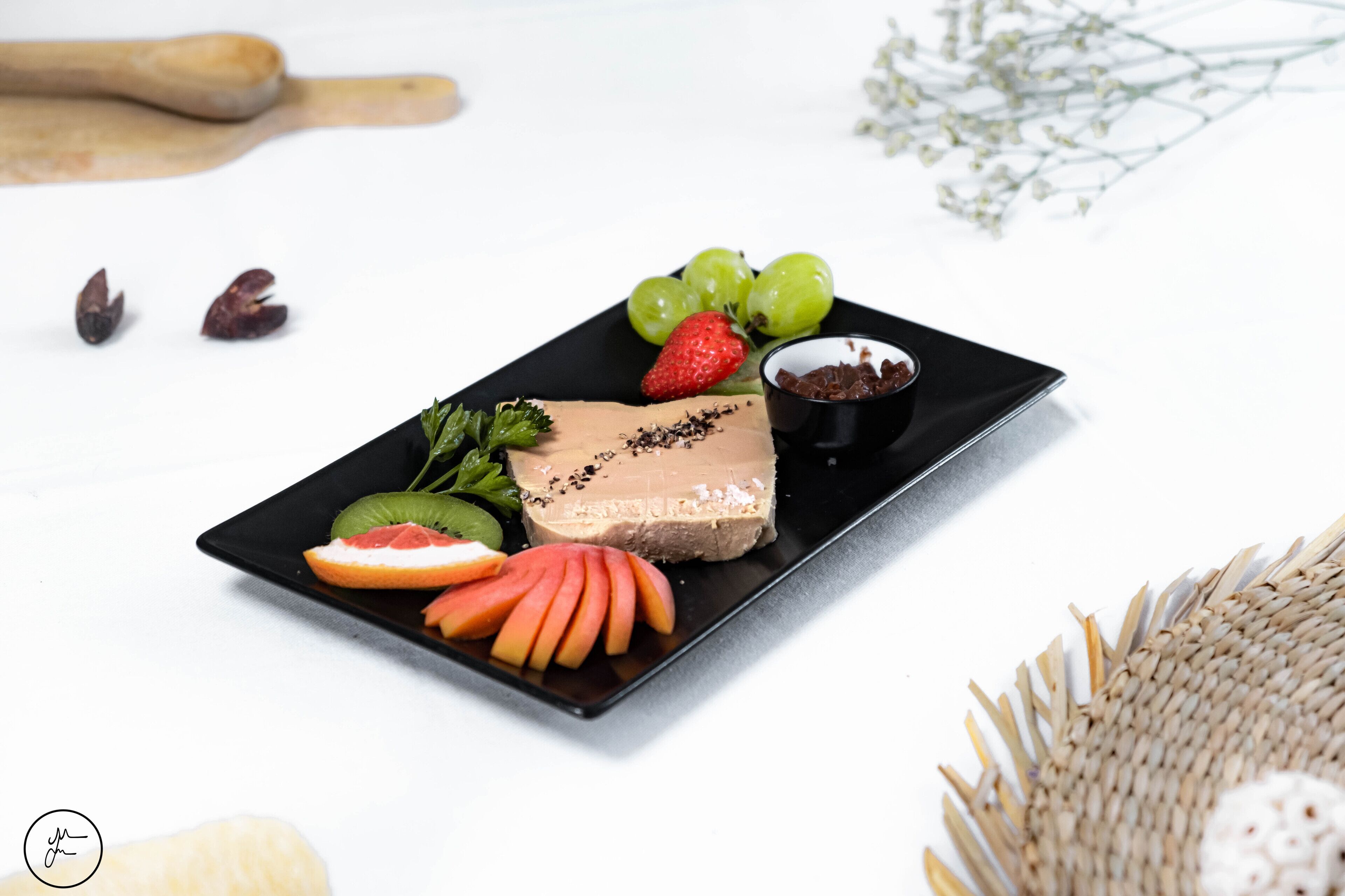 A dessert plate with chocolate mousse, strawberries, grapes, and a small bowl of chocolate shavings.
