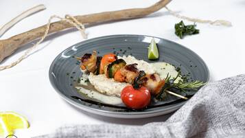 A plate of grilled vegetables and rice on a white tablecloth.