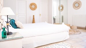 A bedroom with a bed, bedside table, lamp, and decorative items.