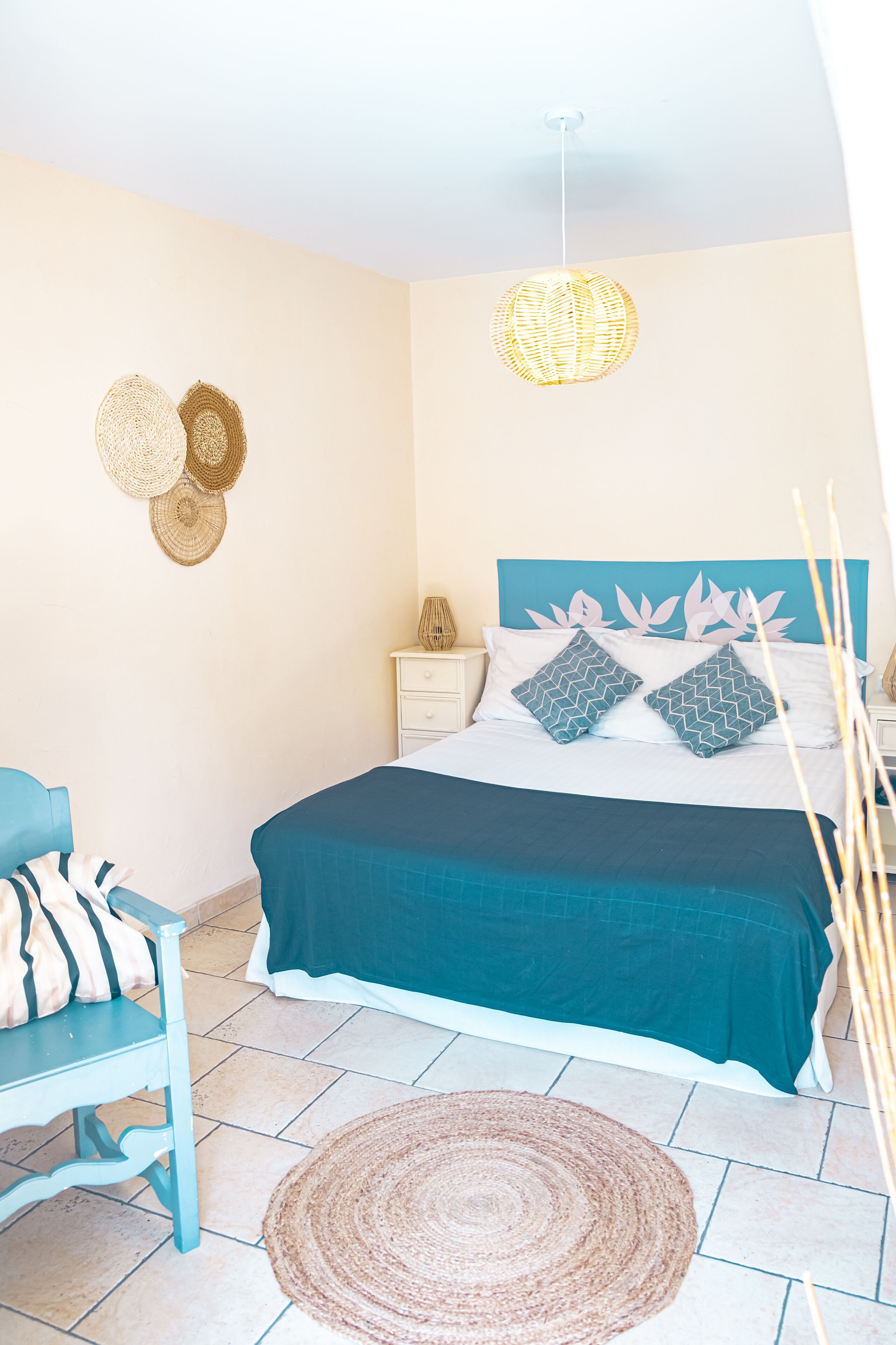 A bedroom with a bed, bedside table, and a chair.