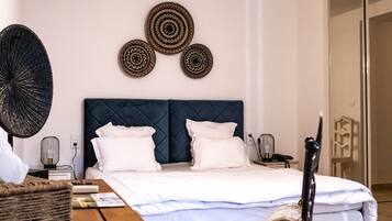 Un dormitorio con cama, mesita de noche, lámpara, decoración en la pared y una silla.
