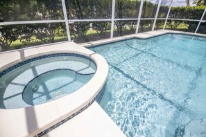 Relax by the pool surrounded by lush greenery and enjoy a serene atmosphere.