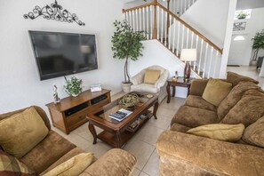 Relax in this stylish living room with a flat-screen TV, comfortable sofa, and potted plant.