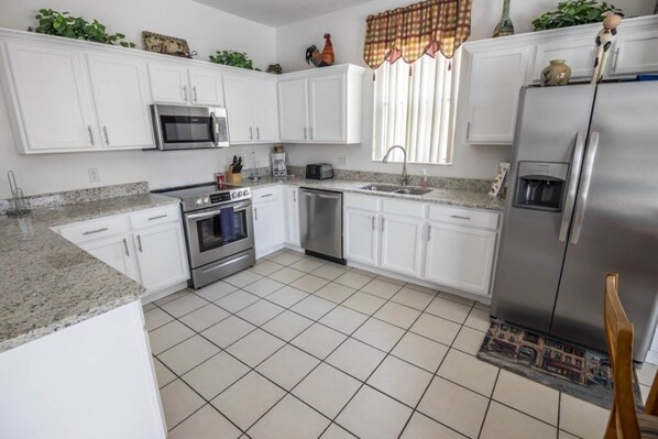 Enjoy cooking in this well-equipped kitchen with a refrigerator, microwave, and dishwasher.