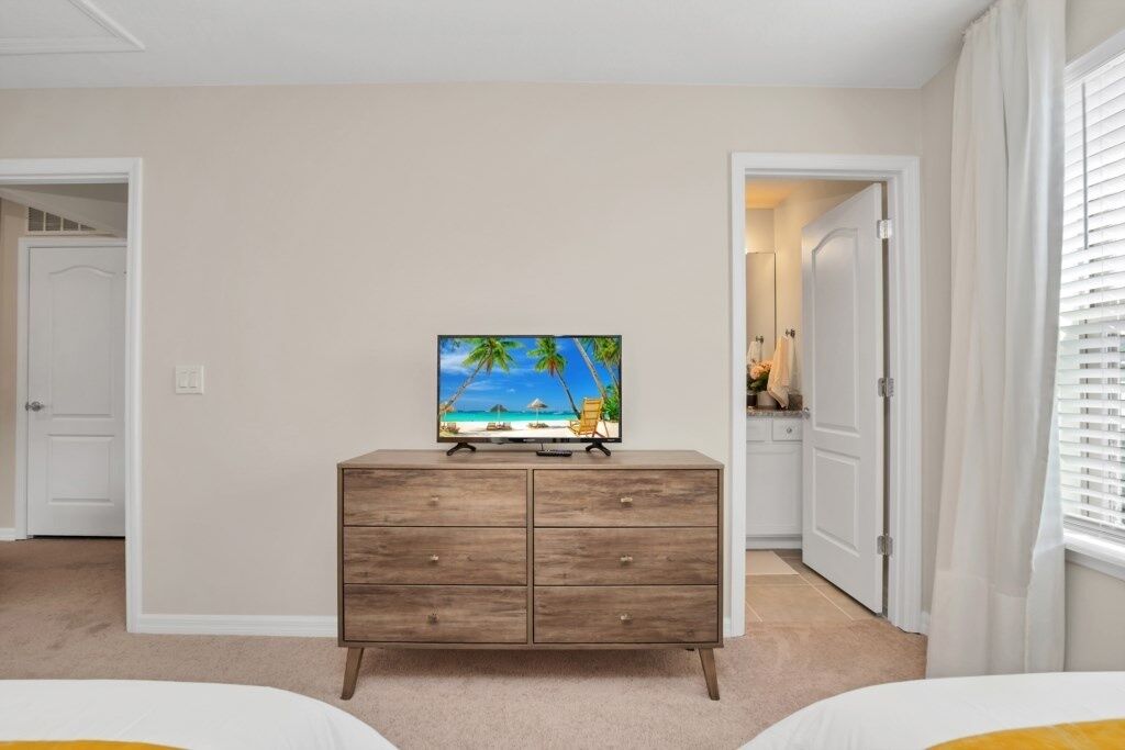 Ein Schlafzimmer mit einem Holzkapfen, einem Fernseher darauf und zwei Betten.