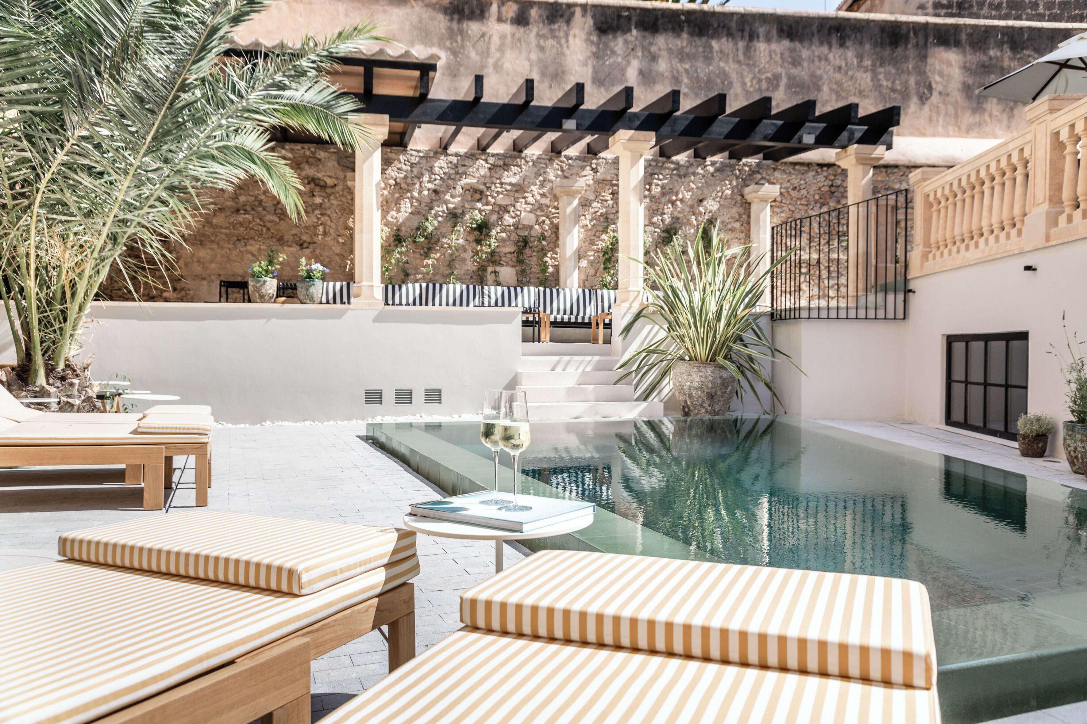 Una piscina al aire libre, sombrillas, tumbonas