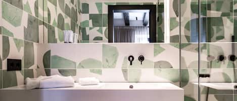 A modern bathroom with a large mirror, a white sink, and a glass shower enclosure.