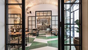 Un restaurante con suelo de tablillas, una zona de bar y vistas a través de amplios ventanales.
