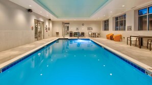 An indoor swimming pool with clear water, tiled walls, and a ceiling with recessed lighting. - Hilton Garden Inn Columbus Easton (Columbus)