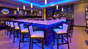 A bar area with a central island, bar stools, and a well-stocked liquor cabinet. - Hilton Garden Inn Columbus Easton (Columbus)