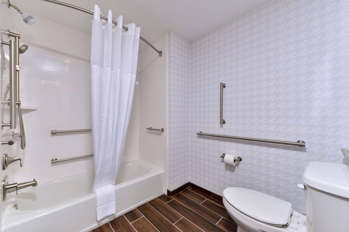 A bathroom with a bathtub, toilet, and shower.
