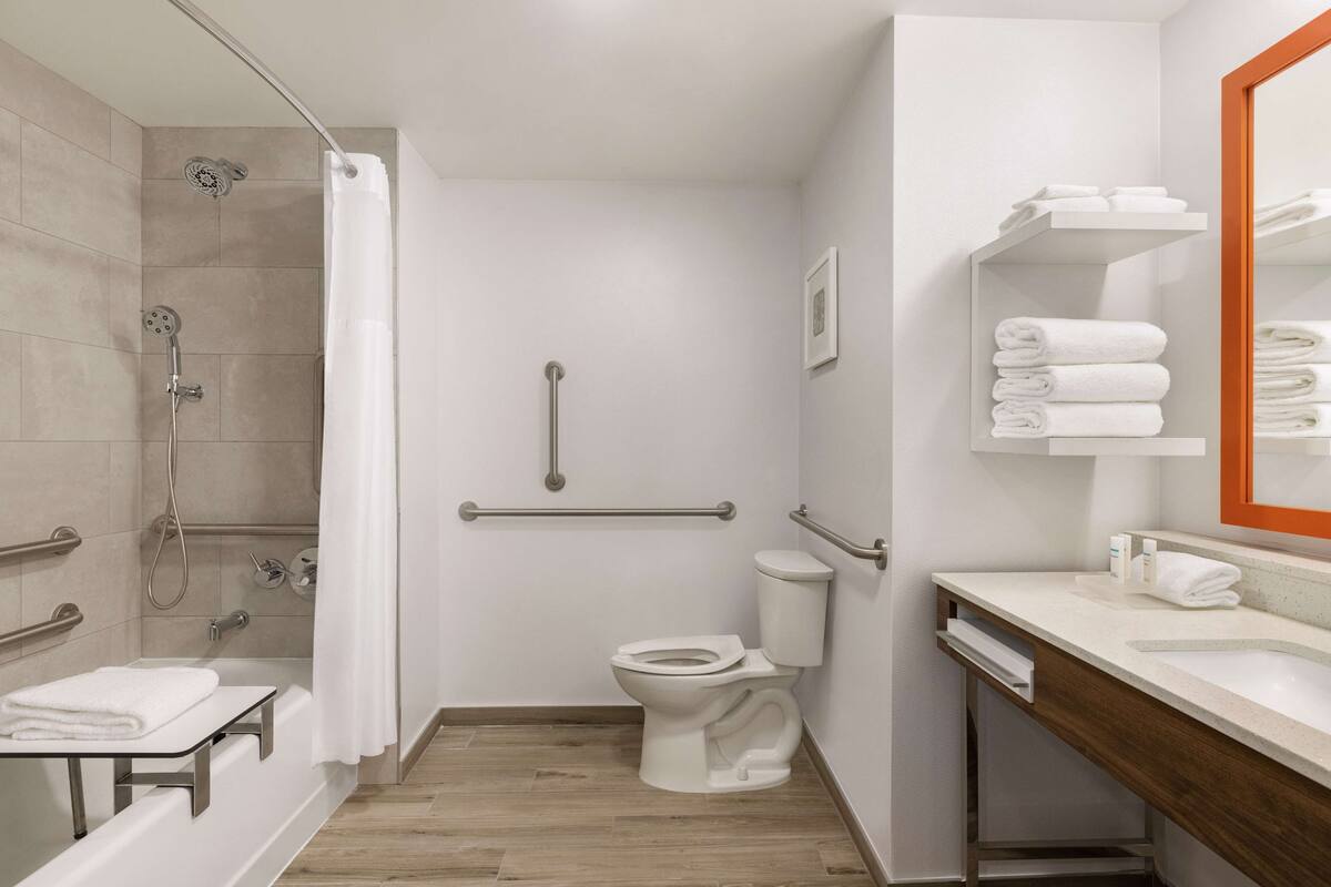 A modern bathroom with a shower, toilet, and sink.