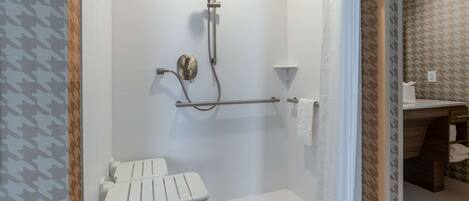 A modern bathroom with a shower, toilet, and towel rack.